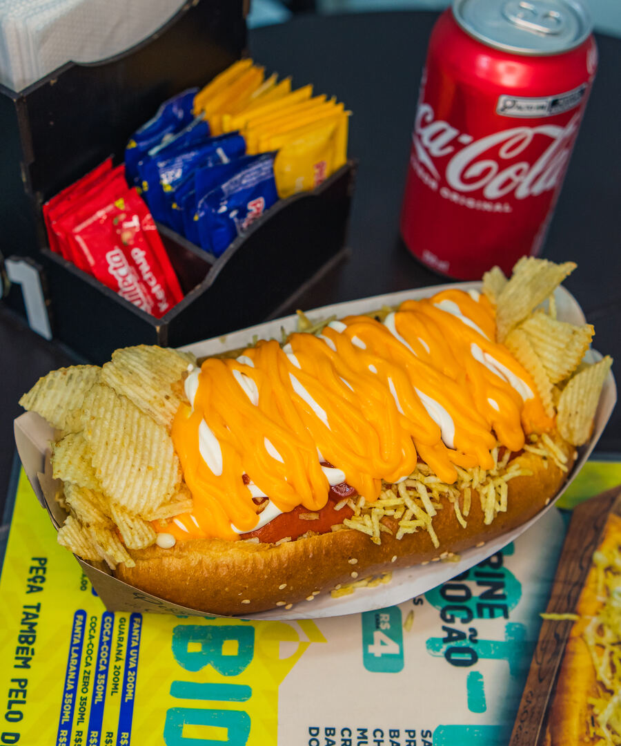 Dog da casa com cheddar cremoso e batata, servido com refrigerante